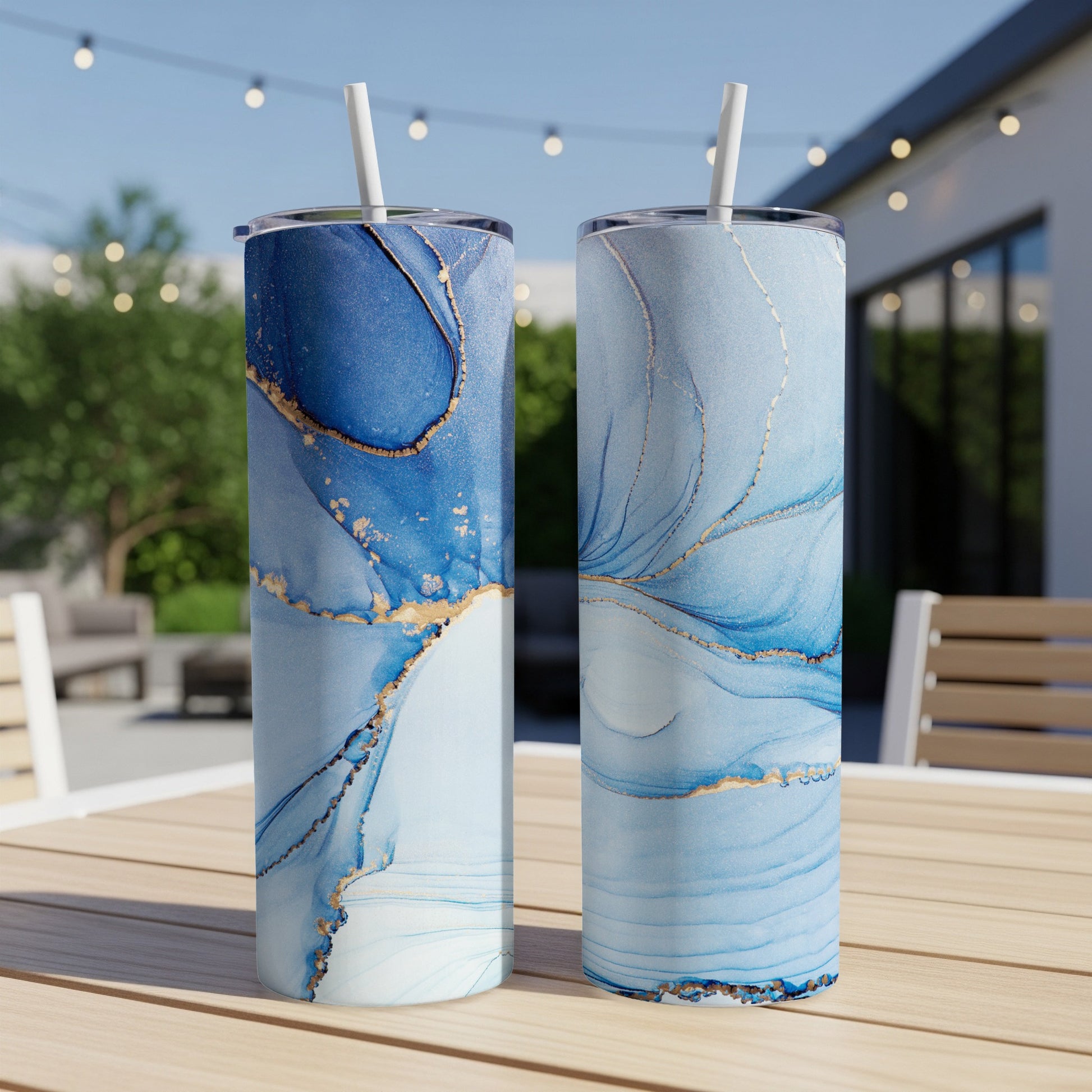 Two tall tumblers with blue and gold marbled patterns, on a wooden table.