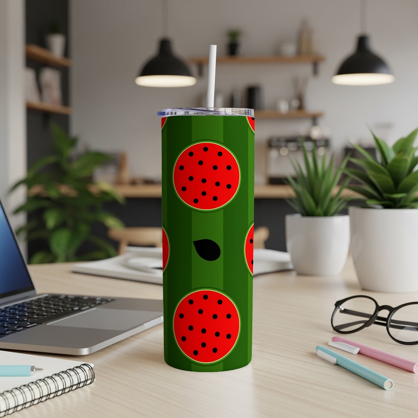 Green tumbler with red watermelon slices and black seeds.