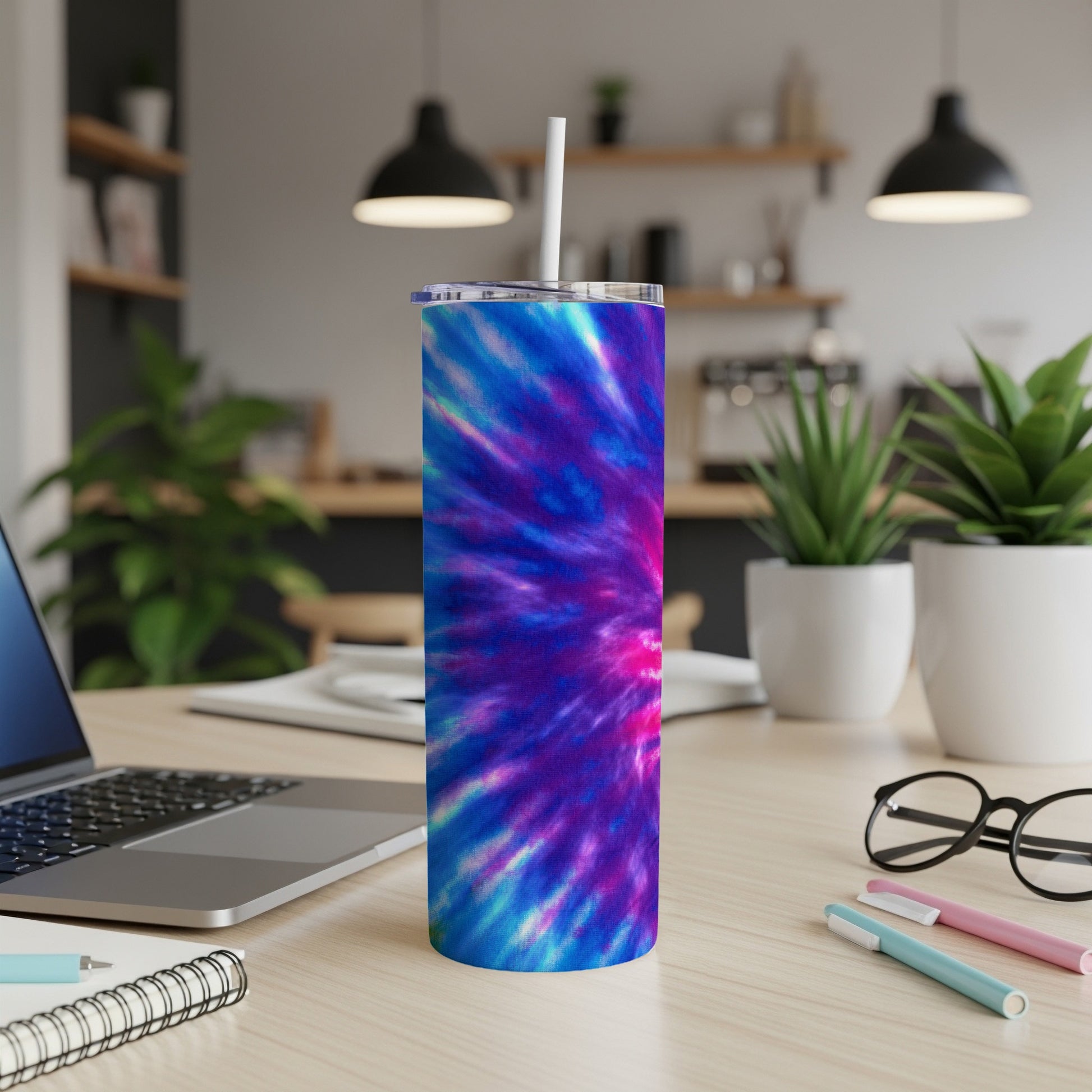 Tall tumbler with tie-dye pattern in blue, purple, and pink, with a white straw.
