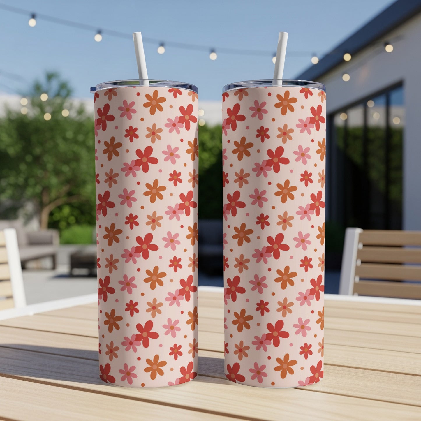 Two tall tumblers with a light pink background and a repeating floral pattern.