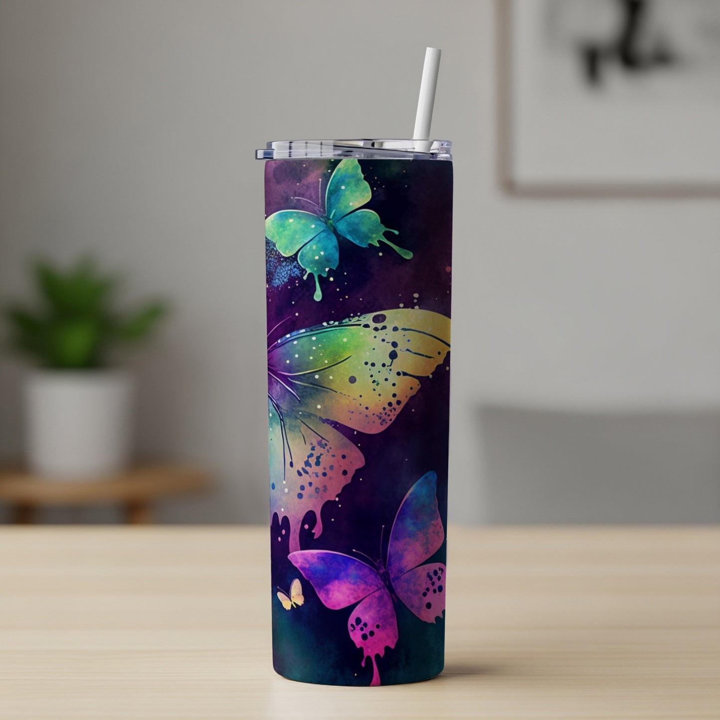 Tall tumbler with colorful watercolor butterfly design and straw.