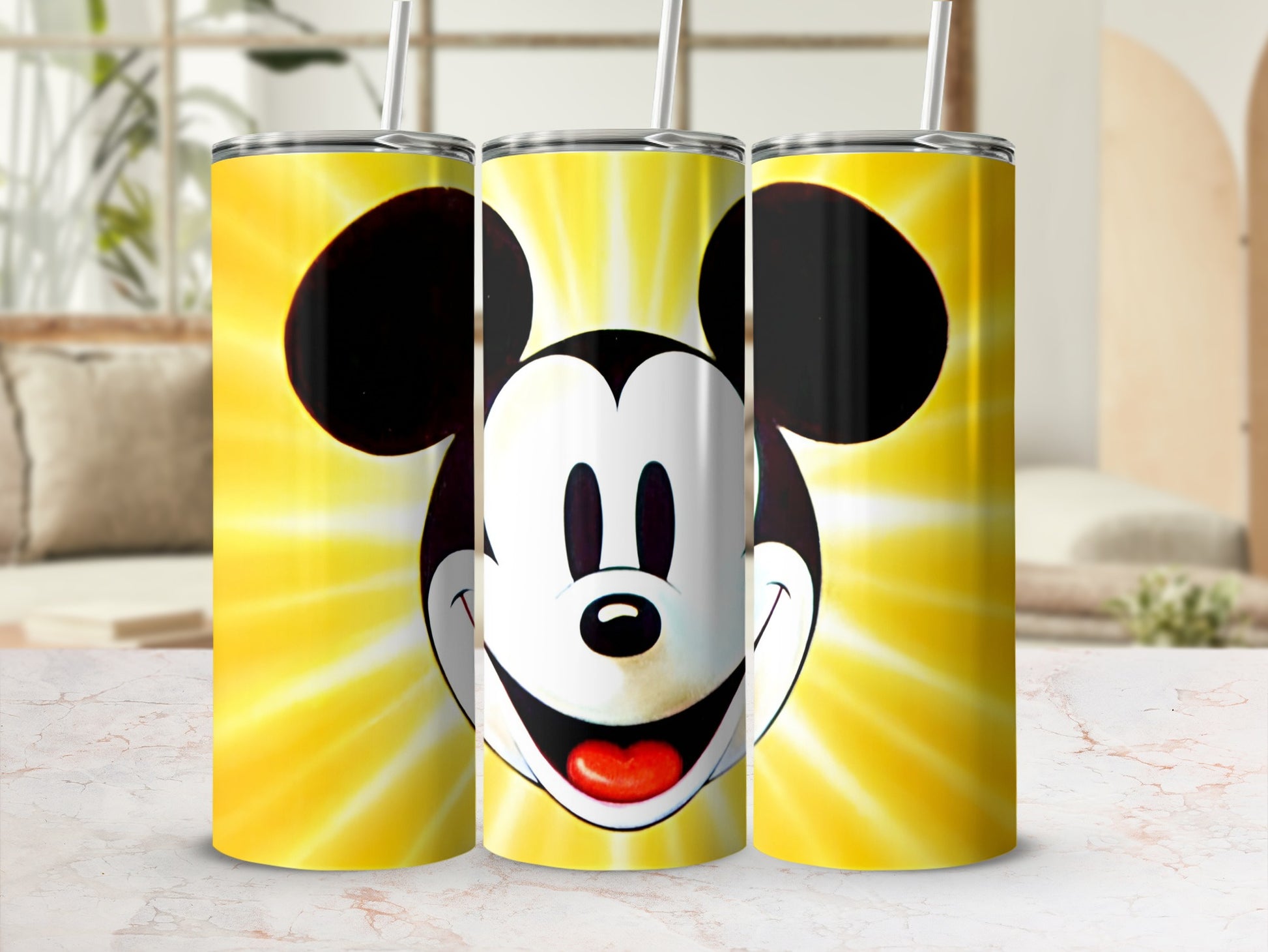 Mickey Mouse face on three yellow gradient tumblers with straws.
