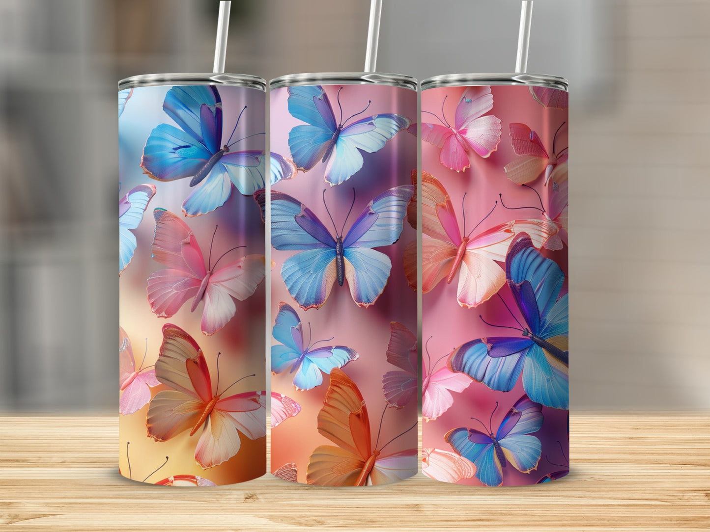 Three tumblers with colorful butterfly designs on a wooden surface.
