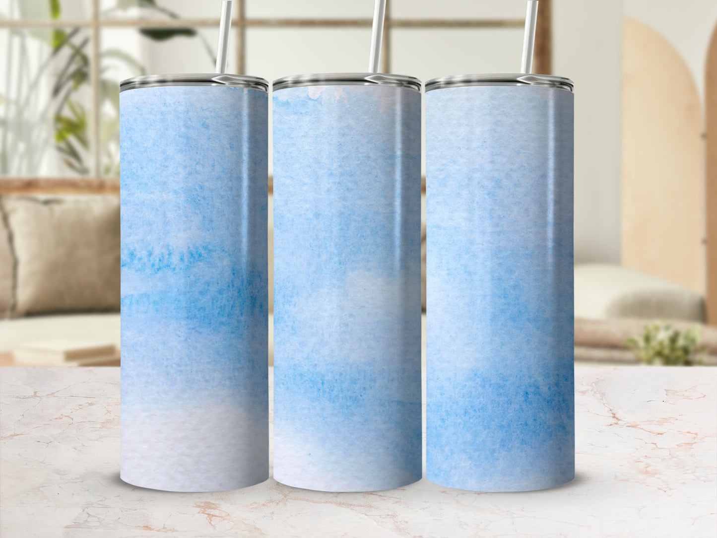 Three blue and white watercolor tumblers with straws.
