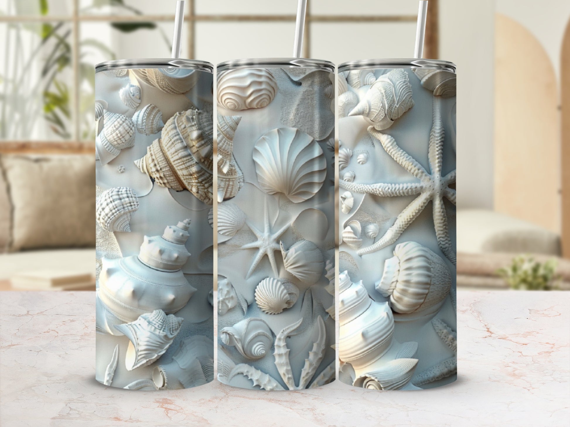White seashell and starfish embossed tumbler with straw on marble counter.