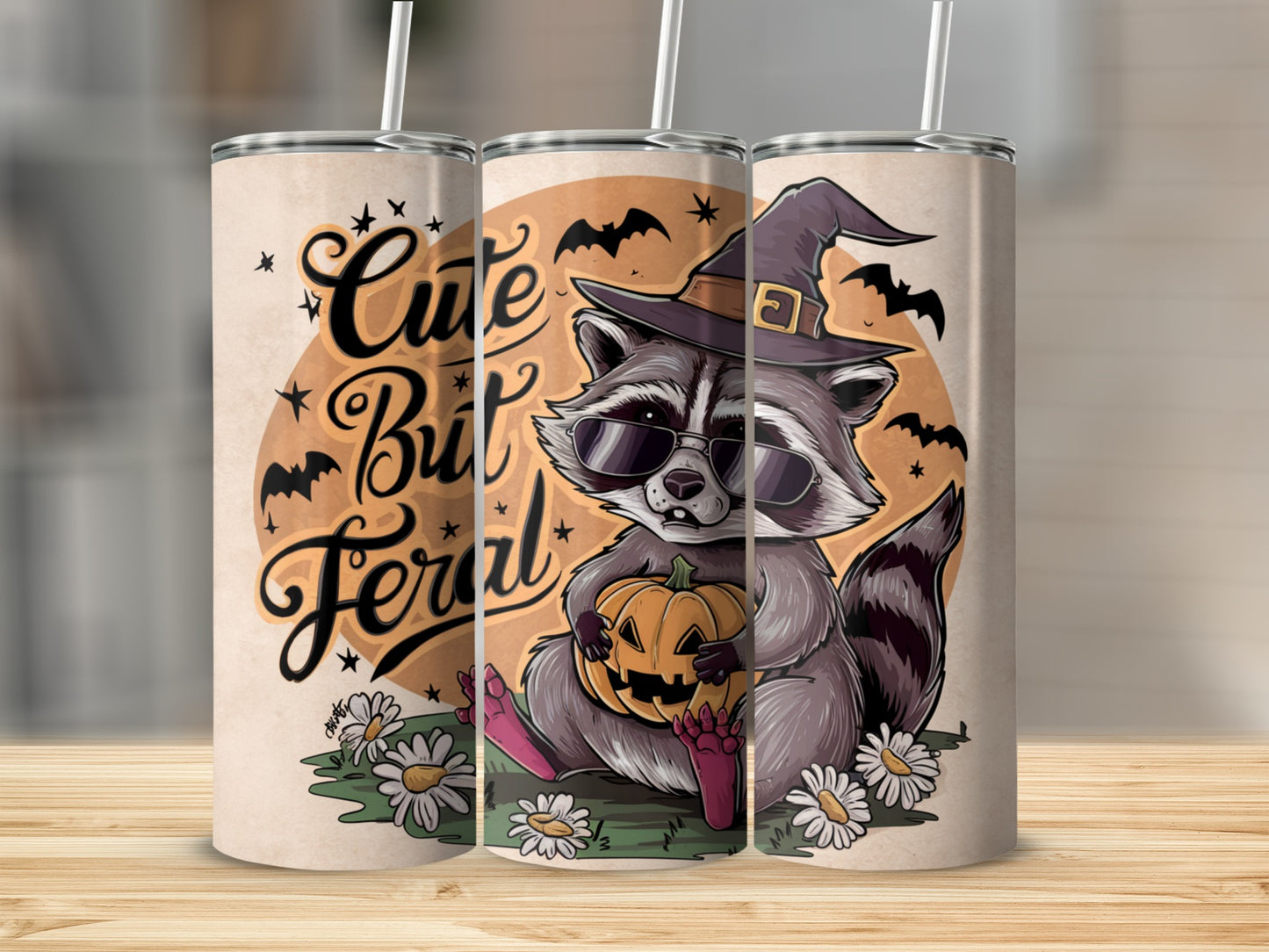 Raccoon in witch hat and sunglasses holds pumpkin with text "Cute But Feral".