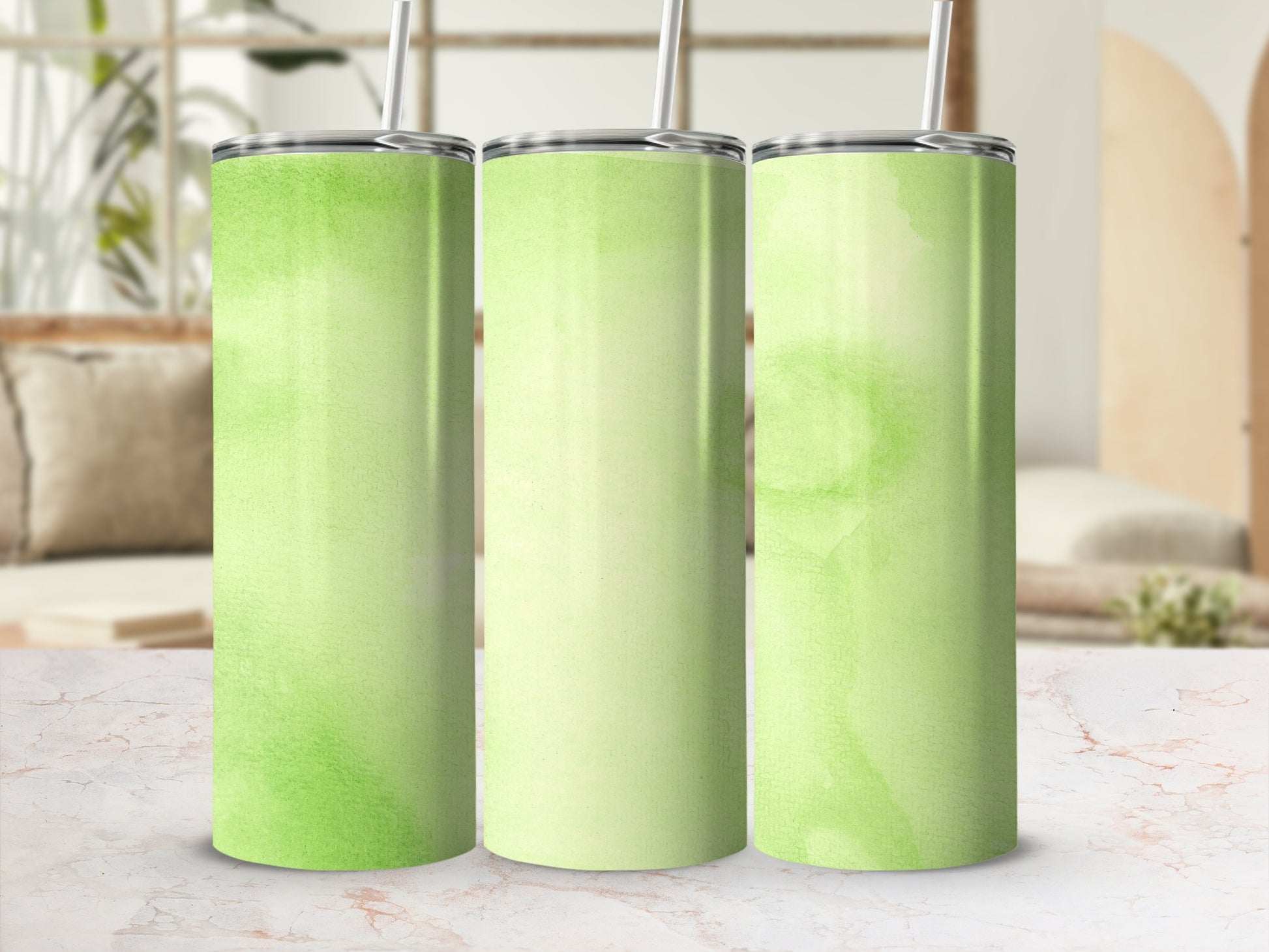 Three tall tumblers with a green watercolor design and straws.