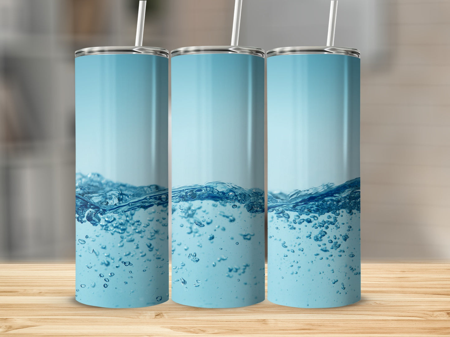 Three tumblers with bubbly water design against a blurred background.