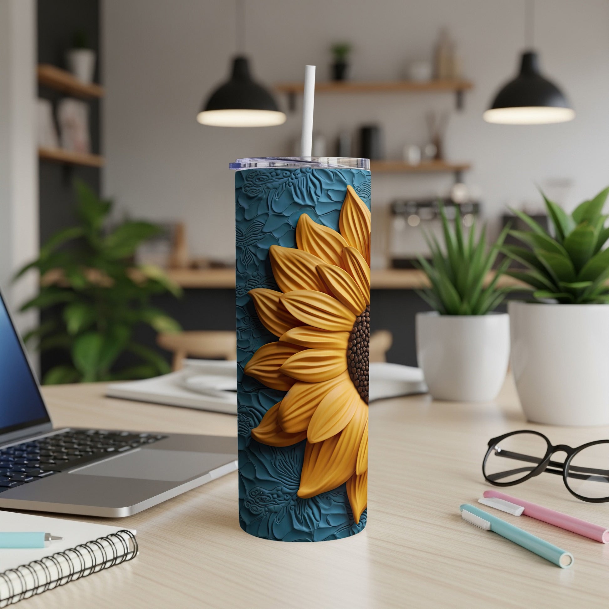 Sunflower tumbler with straw on a desk.