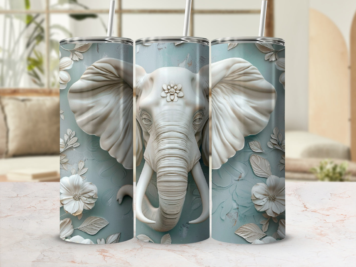 Three tumblers with embossed white elephant and floral designs on a teal textured background.
