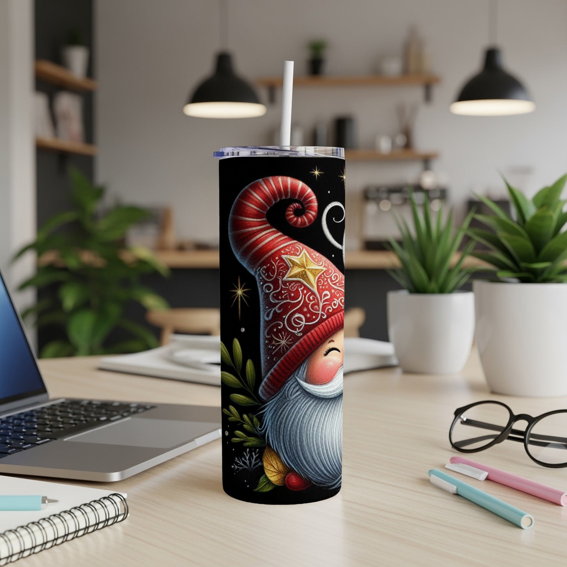 Black tumbler with gnome and star design on desk.