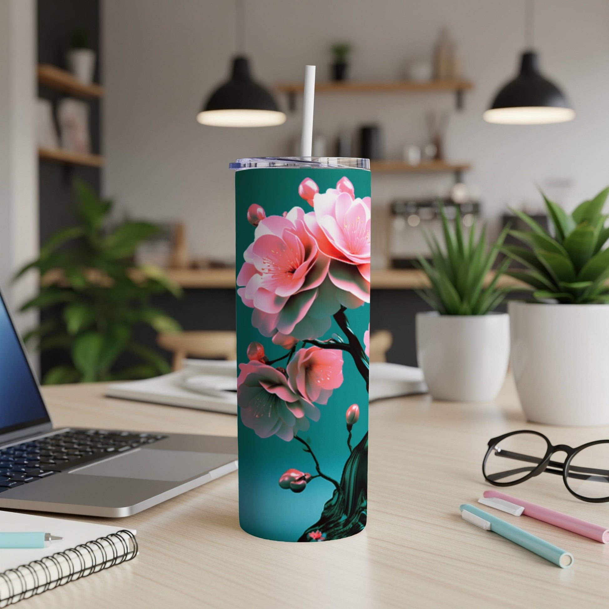 Teal tumbler with pink cherry blossoms and a black straw.