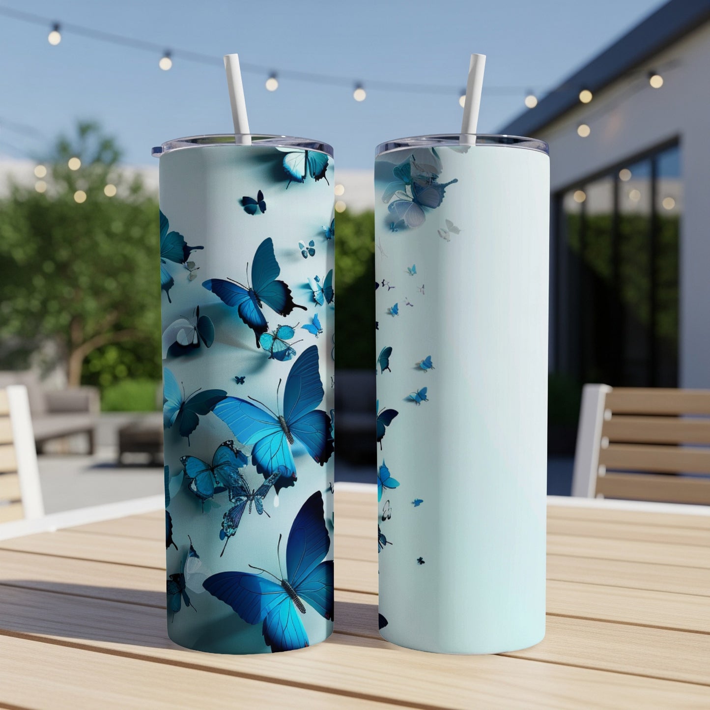 Two light blue tumblers with blue butterflies on an outdoor table.