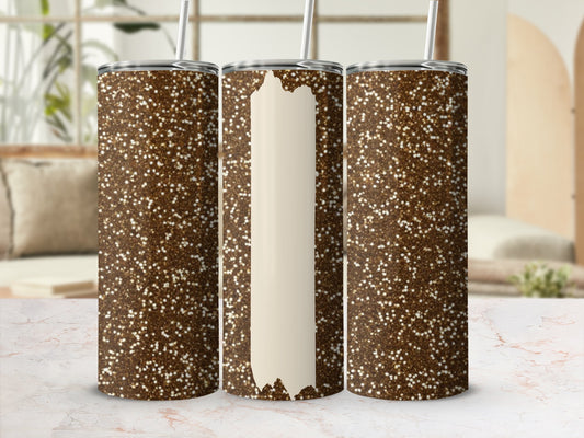 Three glitter tumblers, one with a blank cream label, on a marbled surface.