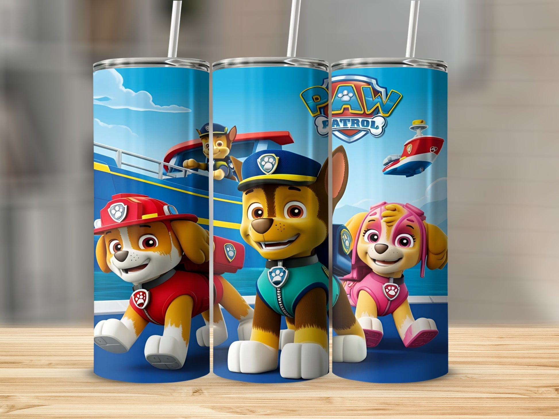 Paw Patrol pups Chase, Marshall, and Skye on a blue tumbler with a straw.