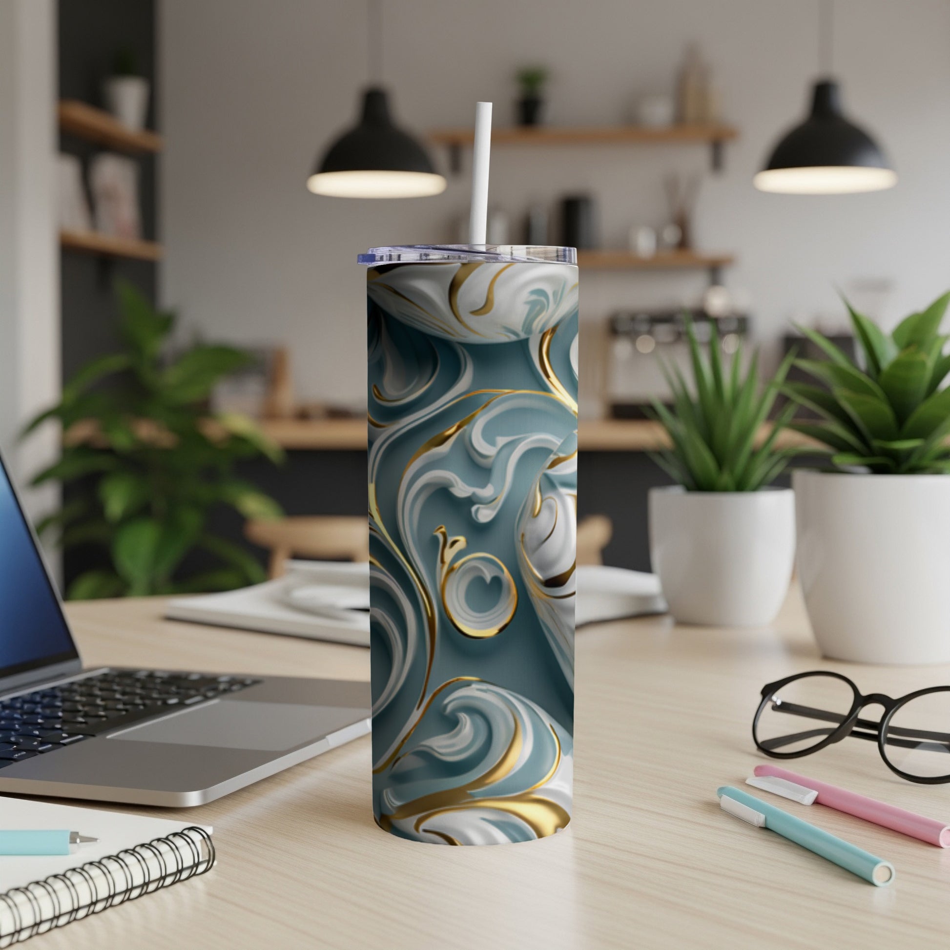 Marble and gold patterned tumbler with straw on a desk.