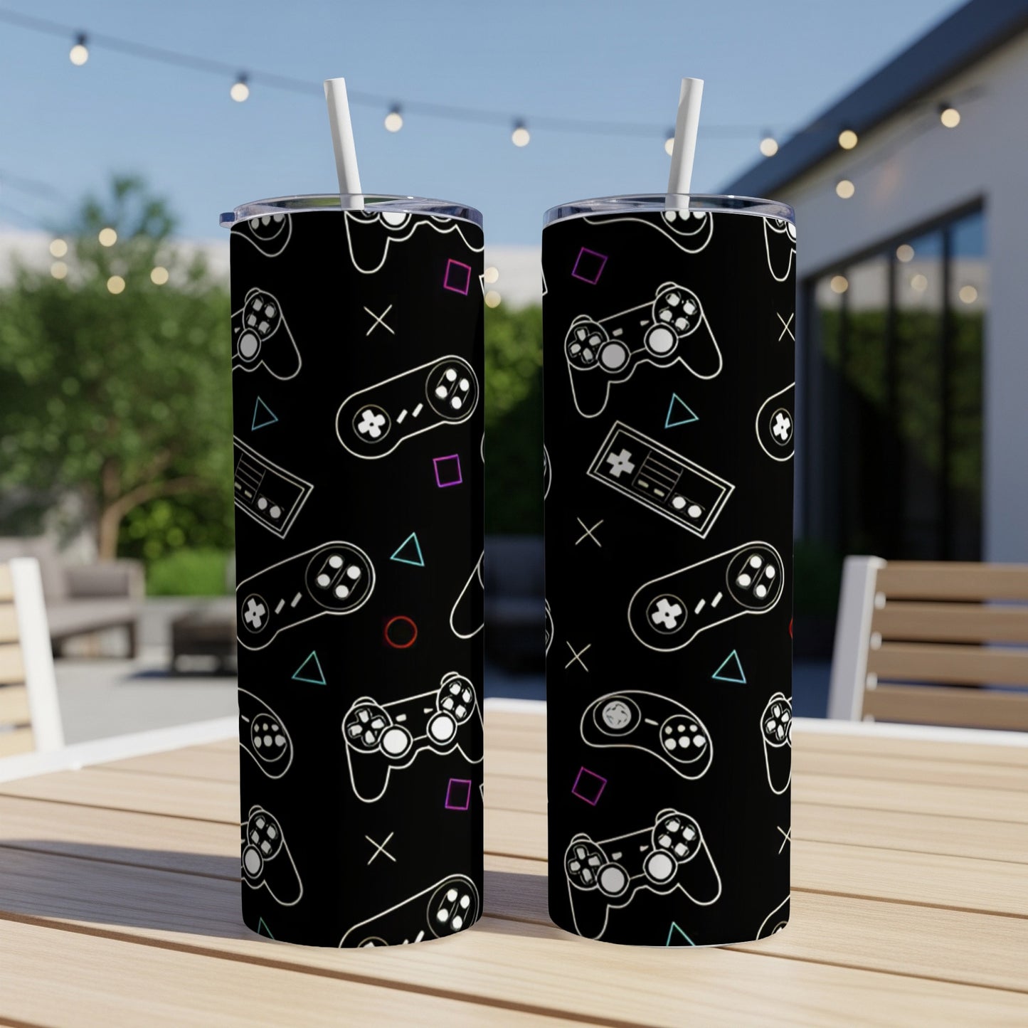 Two black tumblers with a repeating pattern of video game controllers and shapes.