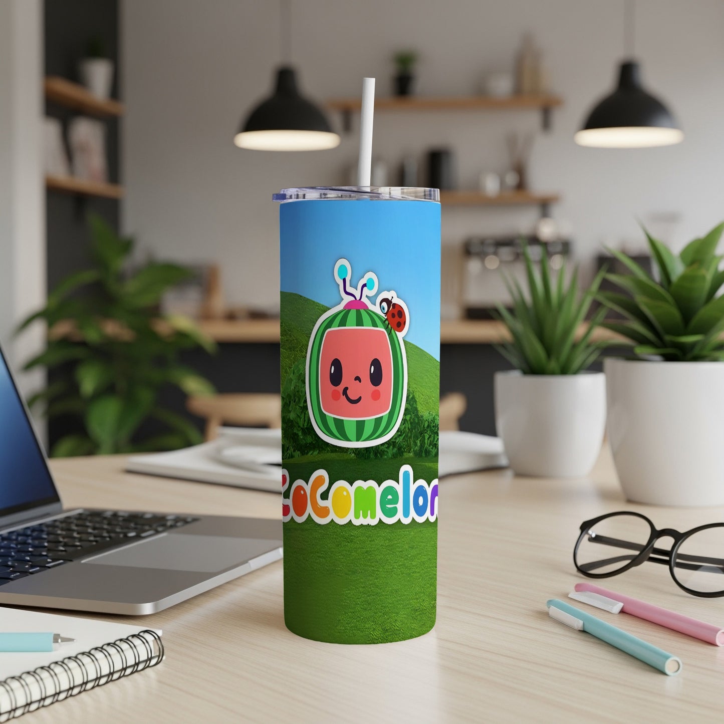 Cocomelon branded tumbler with a character and straw on a desk.