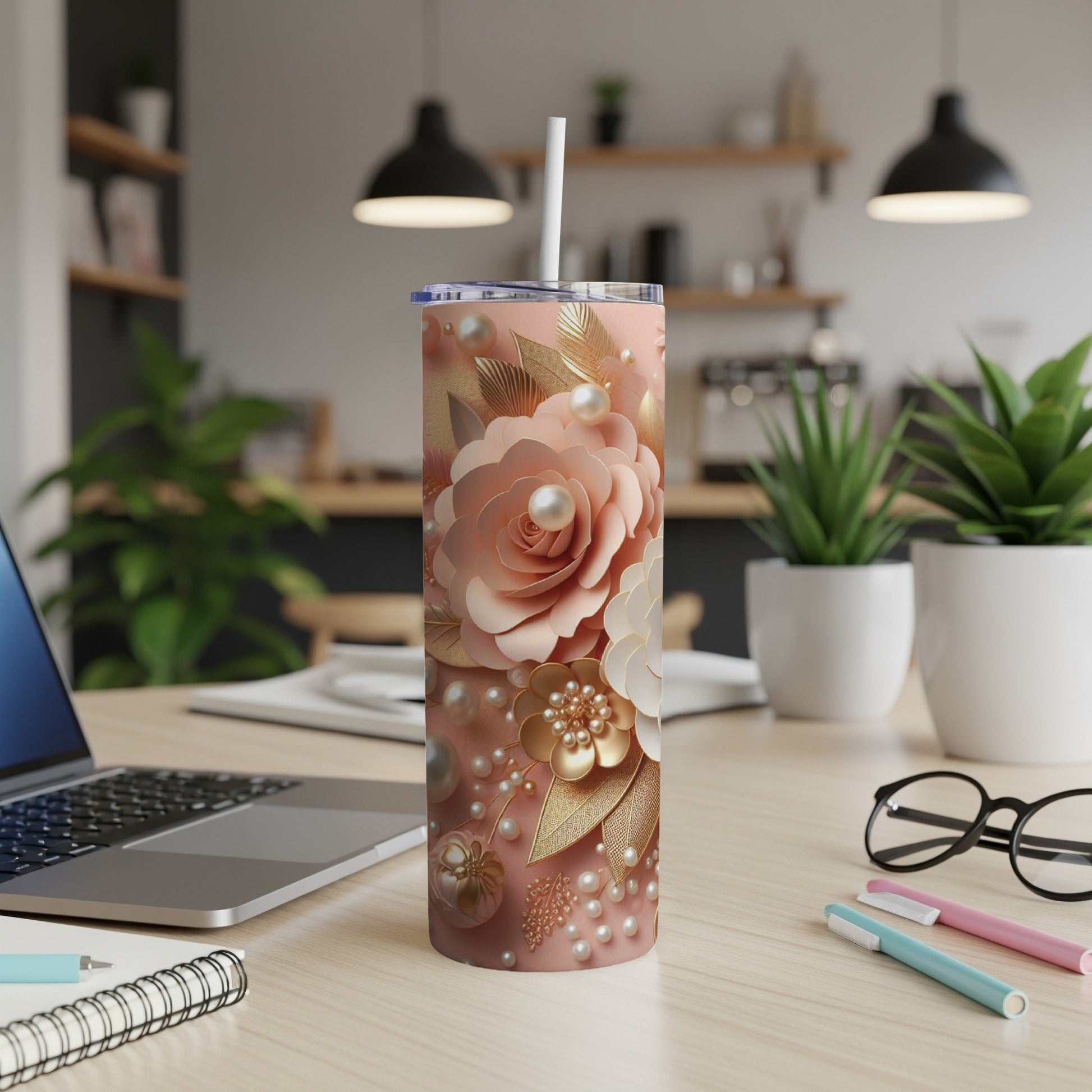 Pink floral pattern skinny tumbler with straw on a desk.
