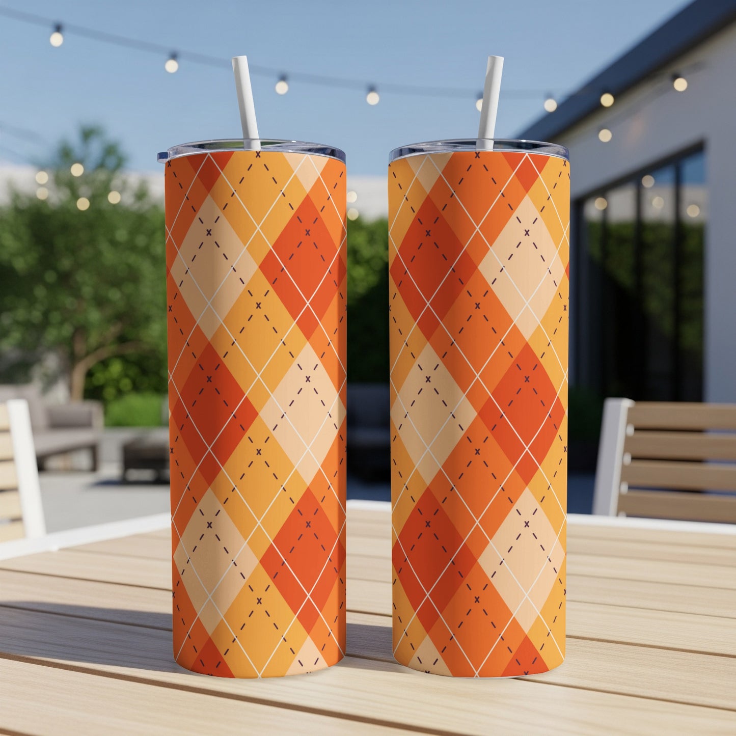 Two tall tumblers with an orange argyle pattern sit on a table.