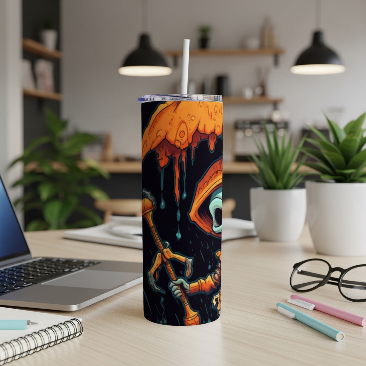 Tumbler with cartoon character artwork and straw, on a desk.