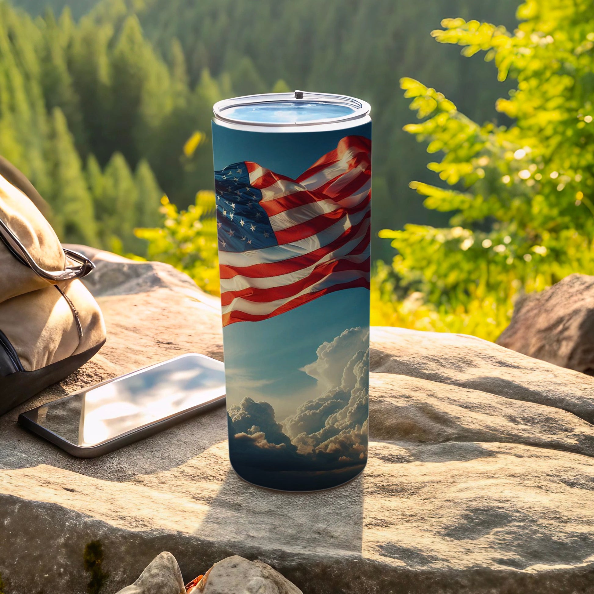 American flag design on a tumbler with phone and backpack outdoors.