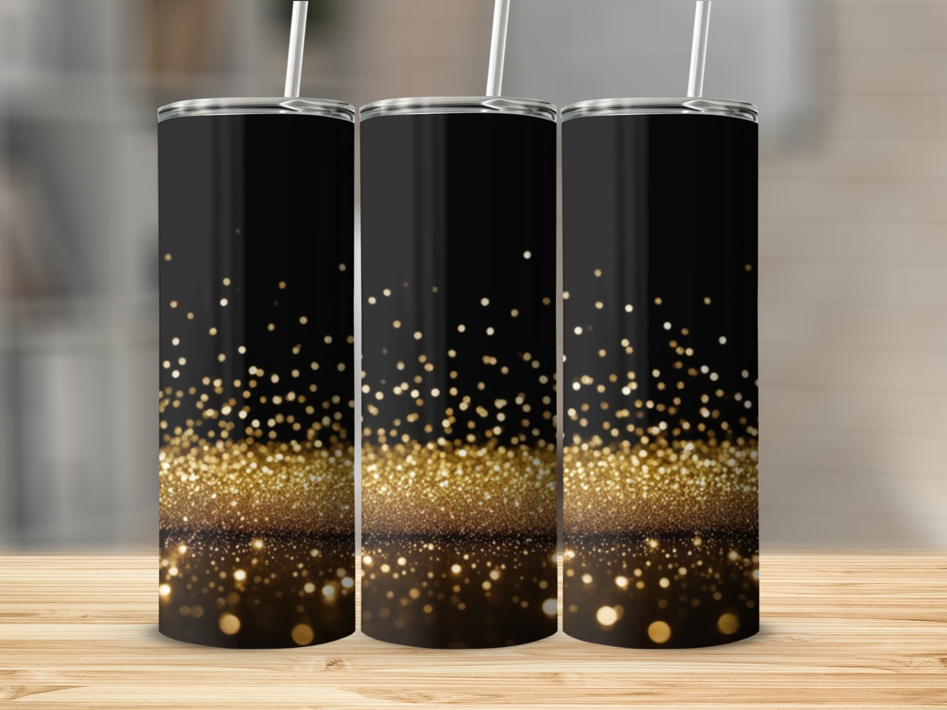 Three black tumblers with gold glitter and bokeh effect, standing on a wooden surface.