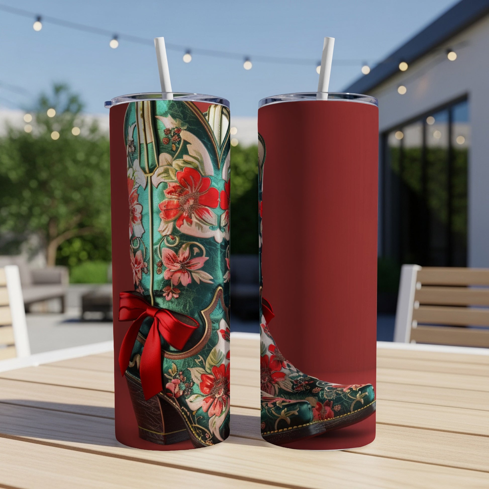 Two green cowboy boots with floral design and red bow, on a table.