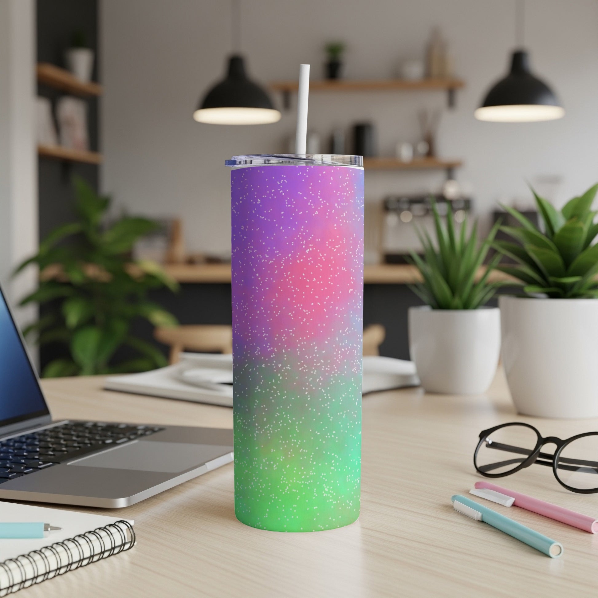 Gradient tumbler with white specks and a straw on a desk.