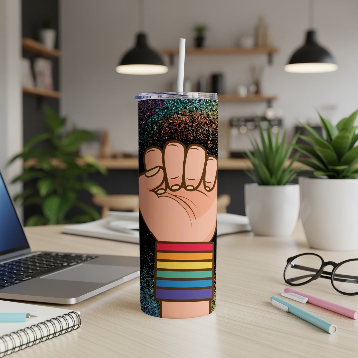 Pride tumbler with raised fist design and rainbow stripes.