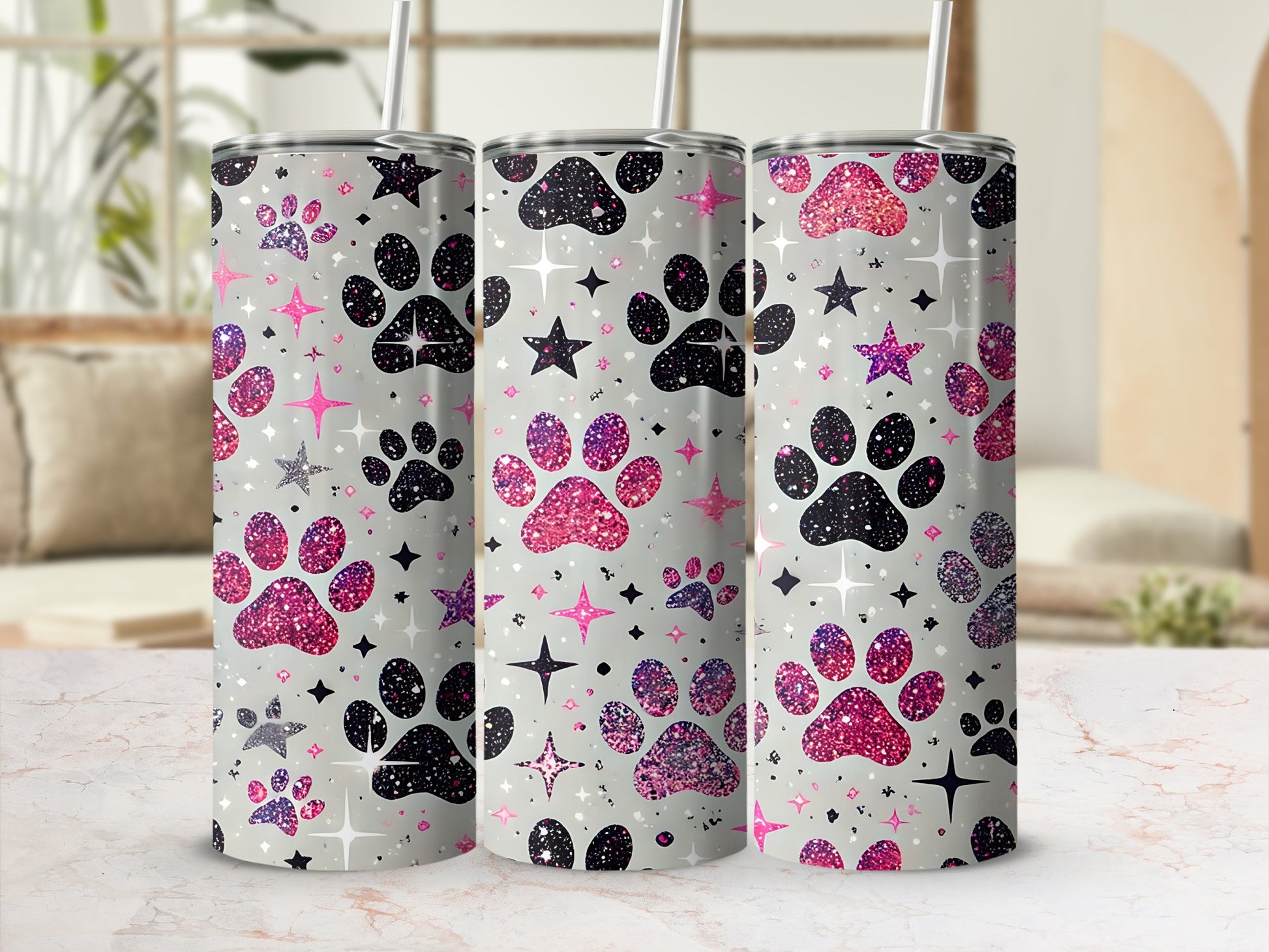 Glittery paw prints and stars adorn three tumblers on a marble countertop.