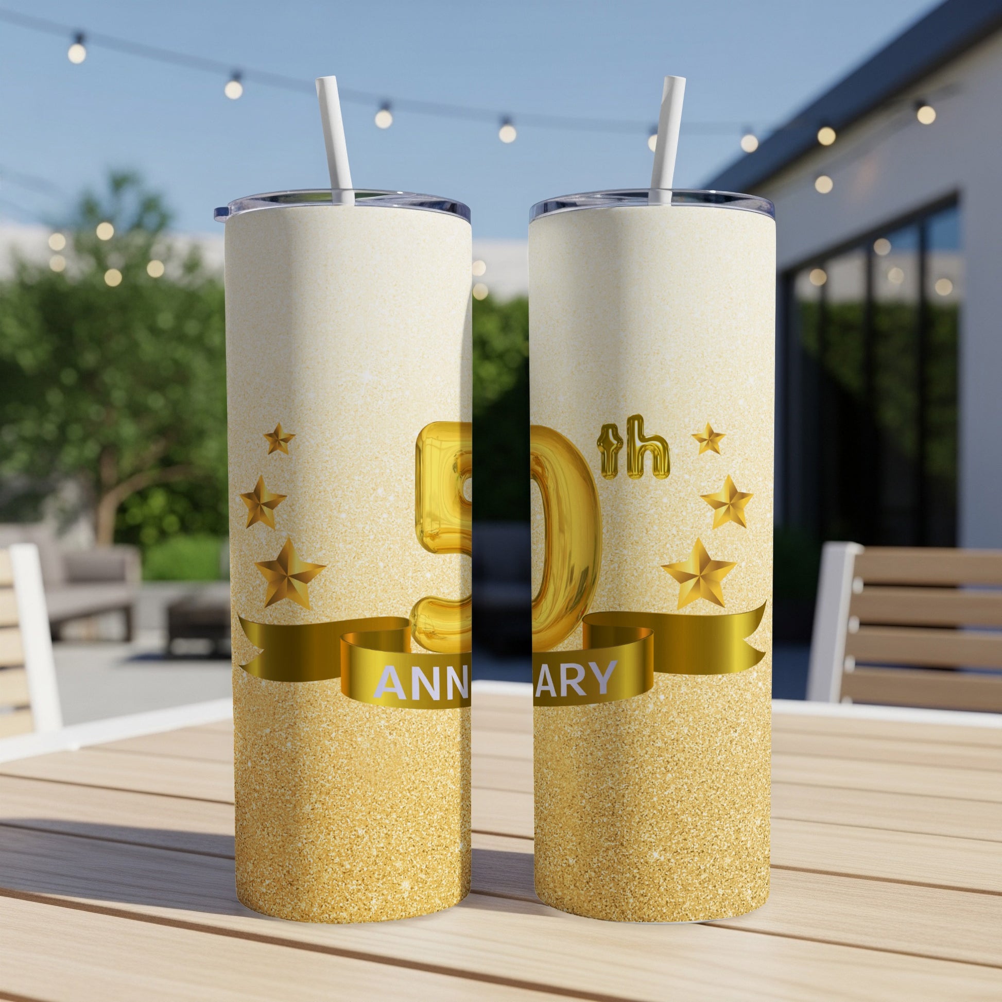 Gold 50th anniversary tumbler with stars and ribbon on a table.