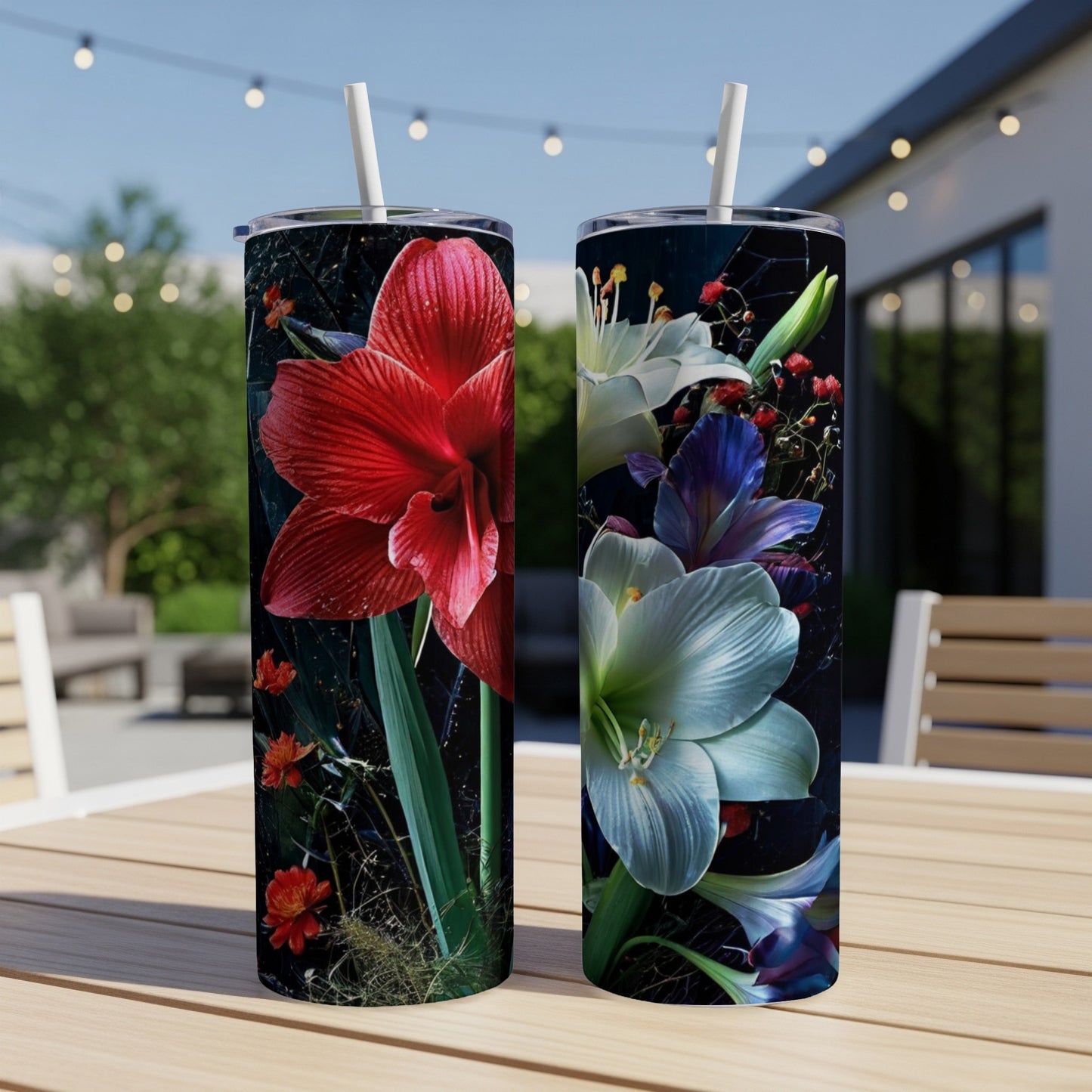 Two tall tumblers with red and white floral designs sit on a wooden table outdoors.