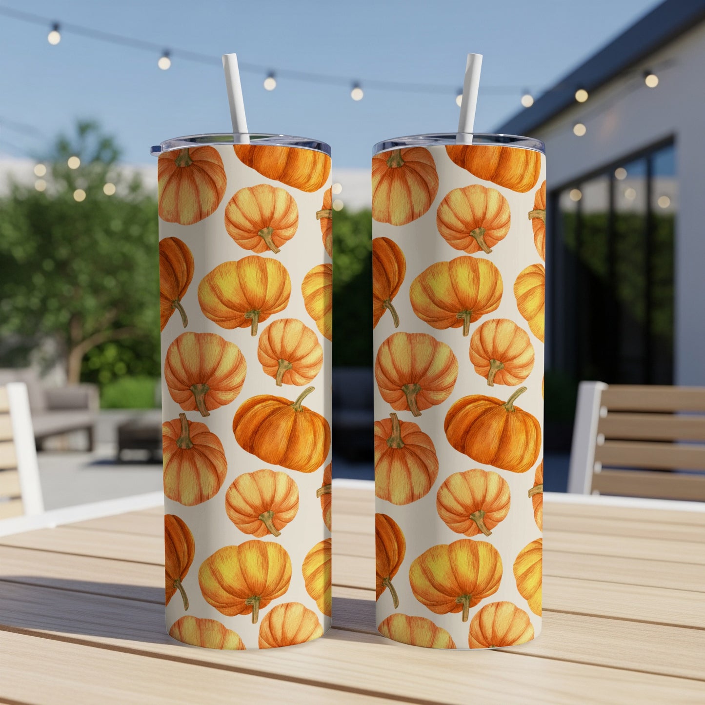 Two tumblers with a repeating pattern of orange pumpkins on a table.