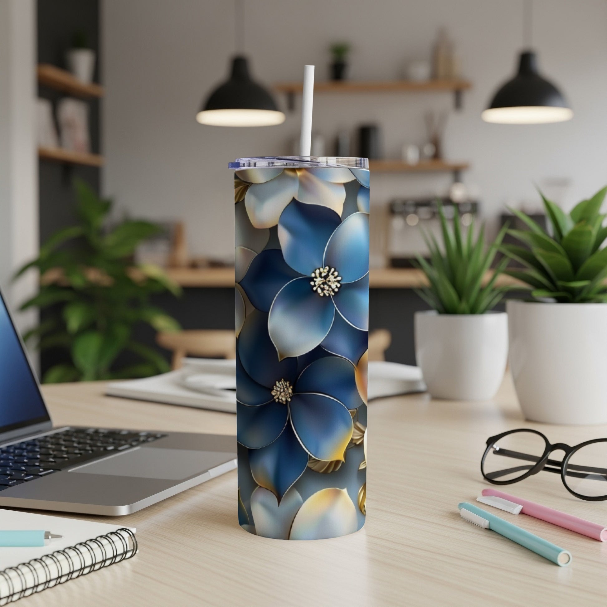 Blue floral patterned tumbler with straw on a desk.