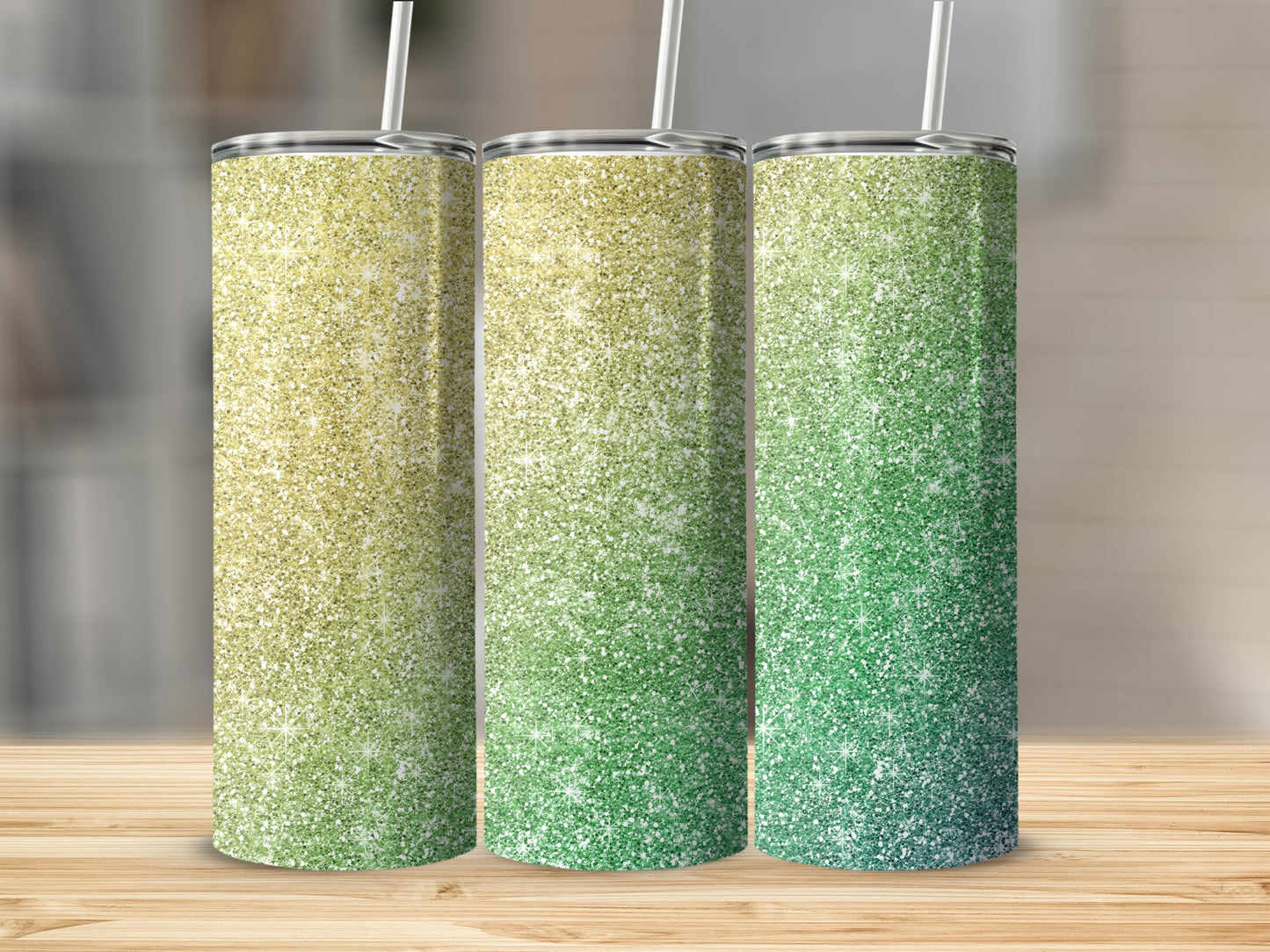 Three glitter tumblers with gradient yellow to green ombre designs and straws.