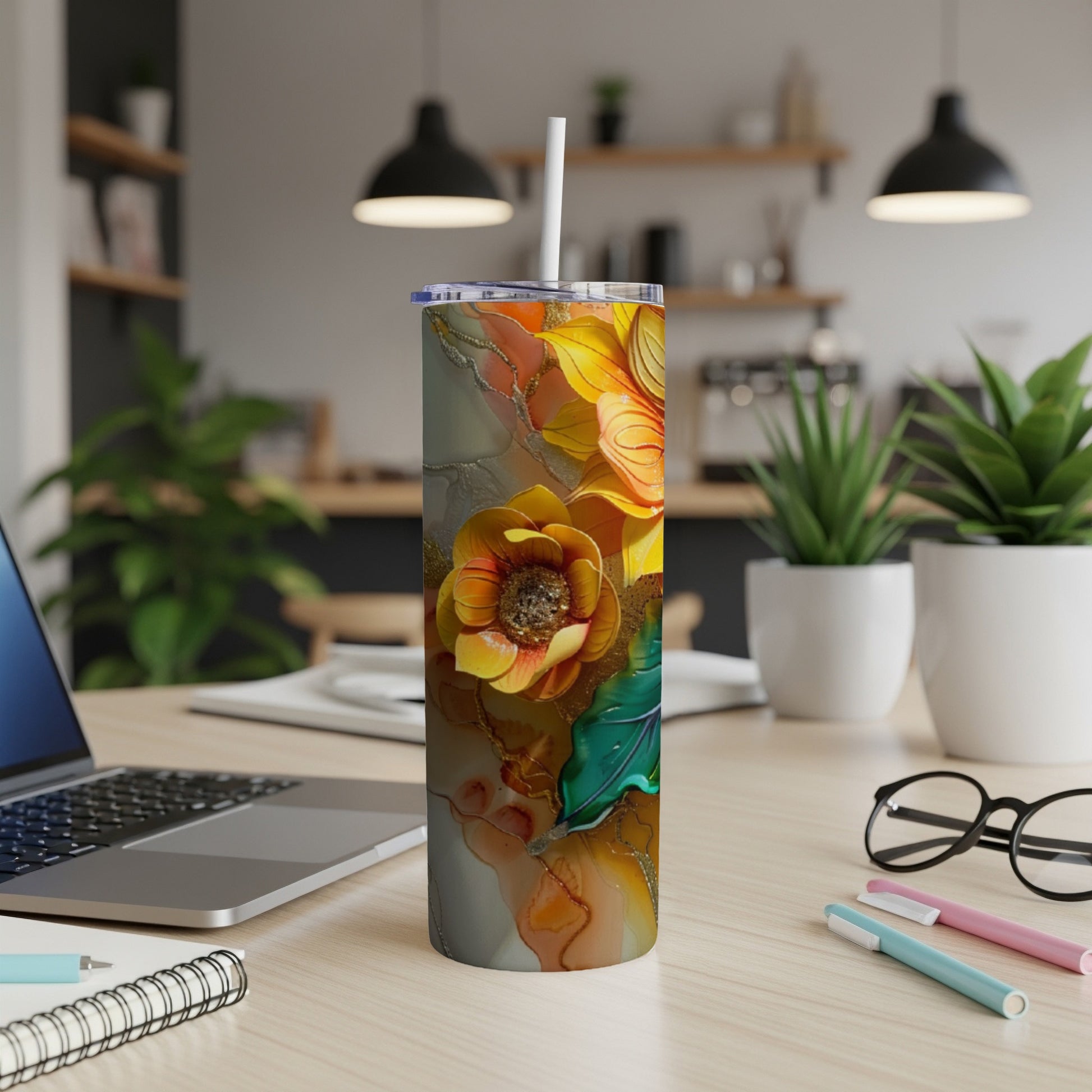 Tall tumbler with a colorful floral design on a desk.