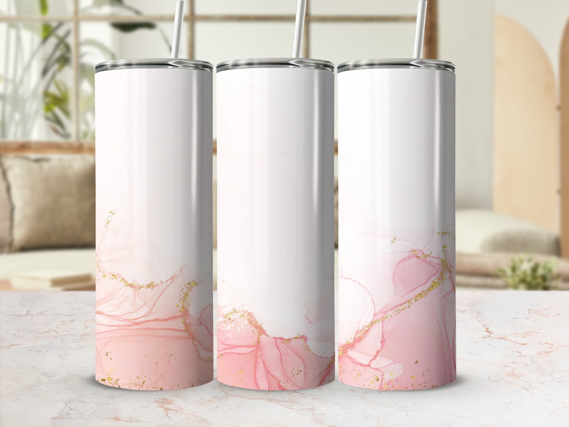 Three white tumblers with pink and gold marbled abstract design and straw.