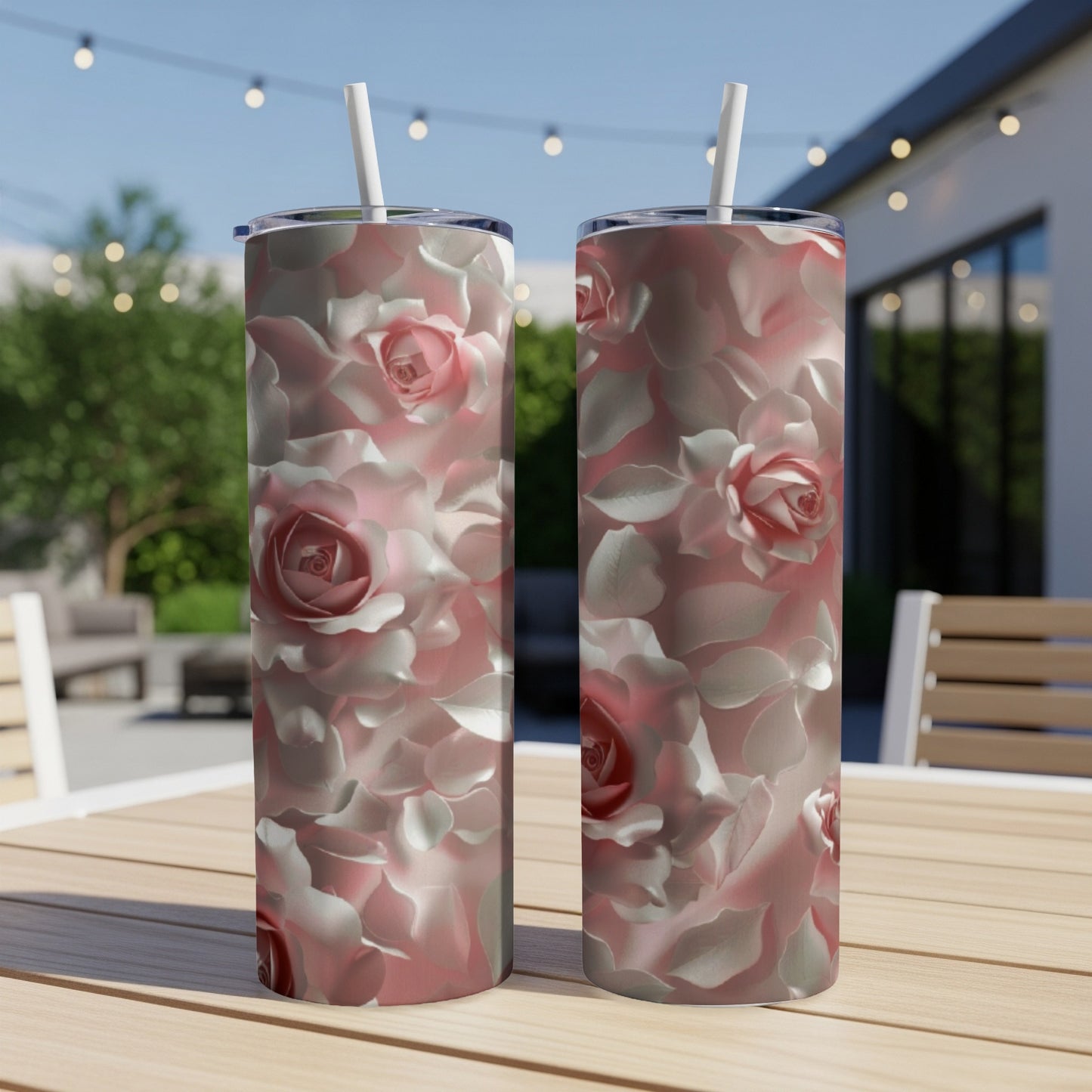 Two tumblers with a pink rose floral pattern sit on a wooden table.