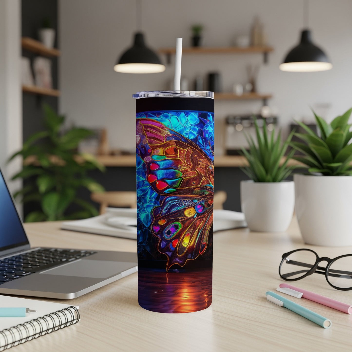 Colorful butterfly design on a tall, slender tumbler with a straw.