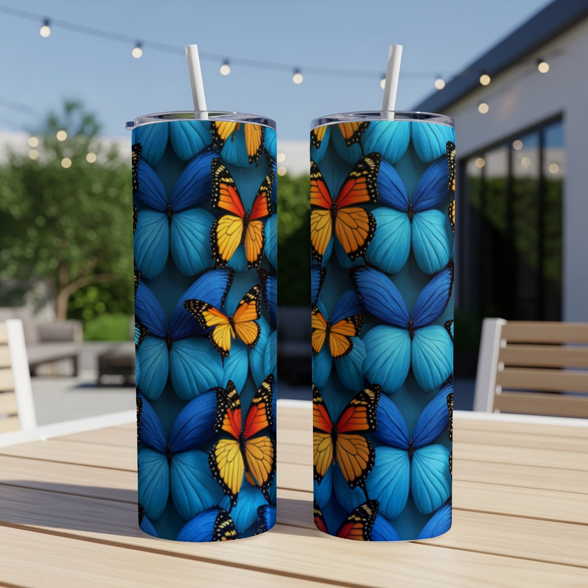 Two tumblers with blue and orange butterfly pattern on a patio table.