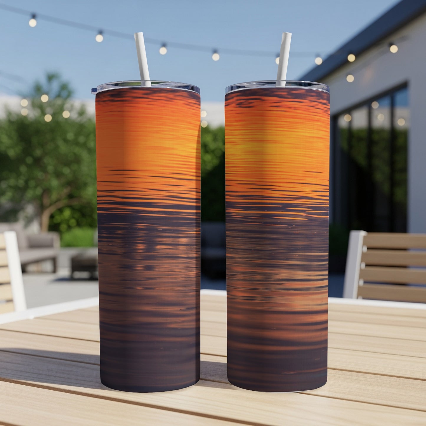 Two tall tumblers with an orange and purple sunset reflection design.