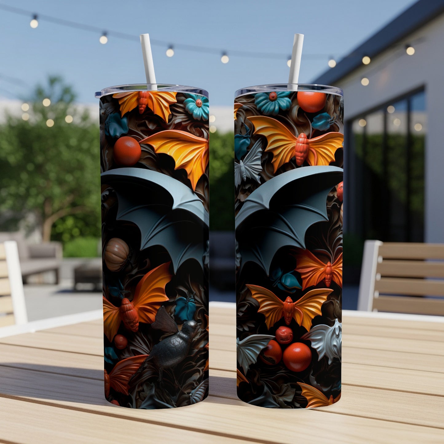 Two tumblers with a Halloween bat and butterfly pattern on a wooden table.