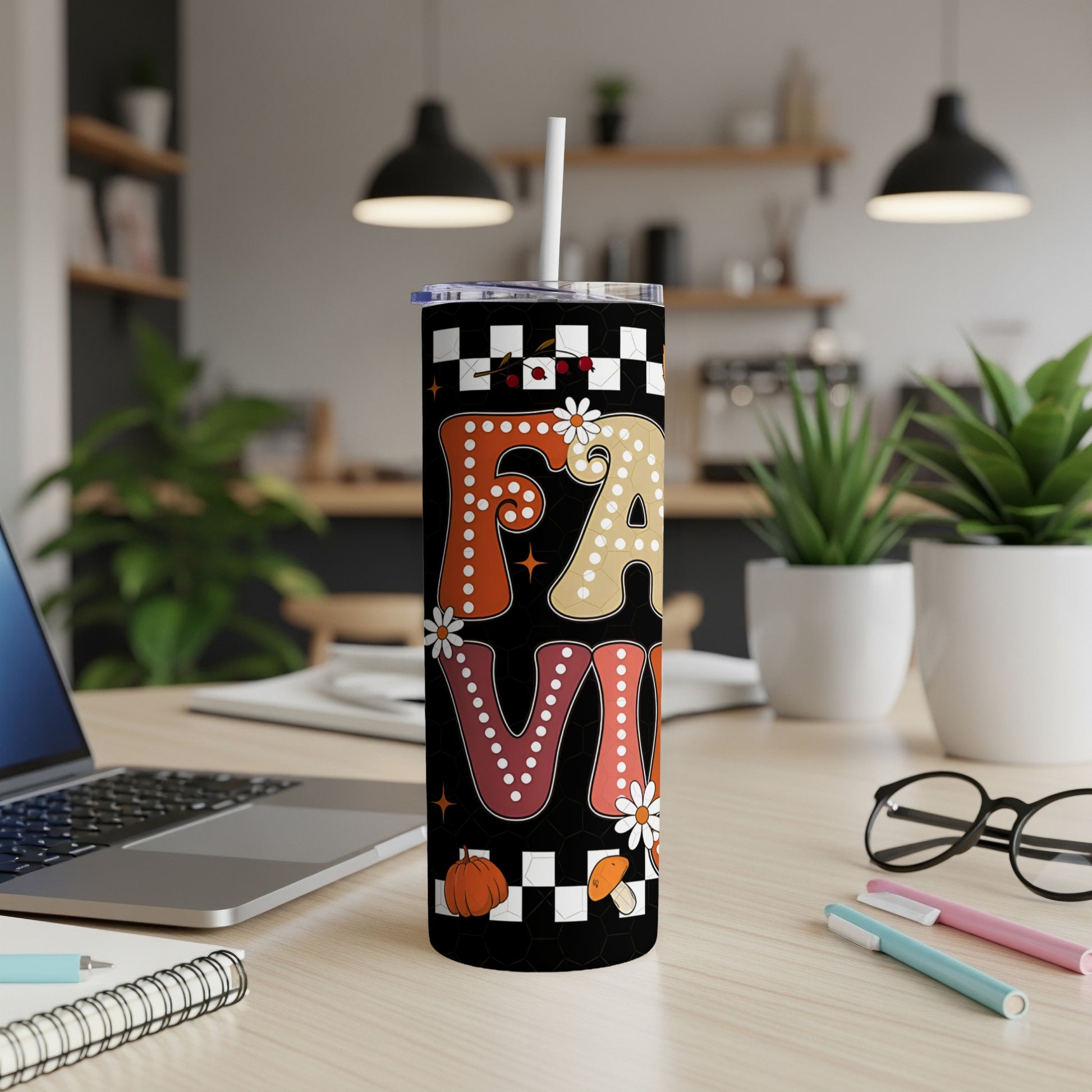 Fall leaves and checkered patterns on a white tumbler with straw.