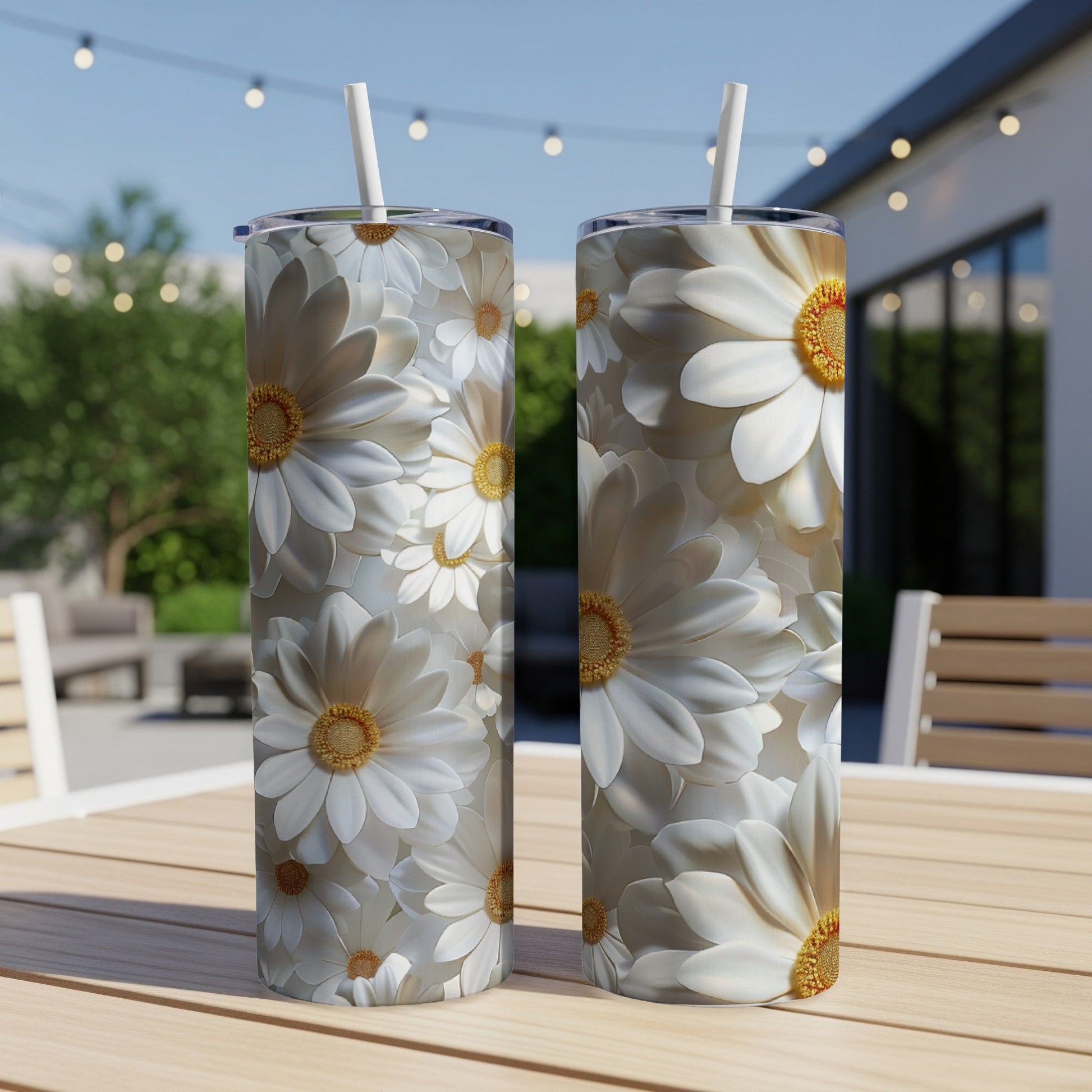 Two white daisy tumblers with straws on a wooden table.