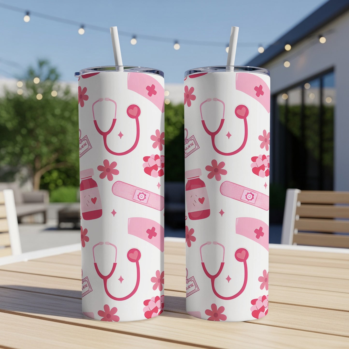 Two white tumblers with a pink nurse-themed pattern on an outdoor table.