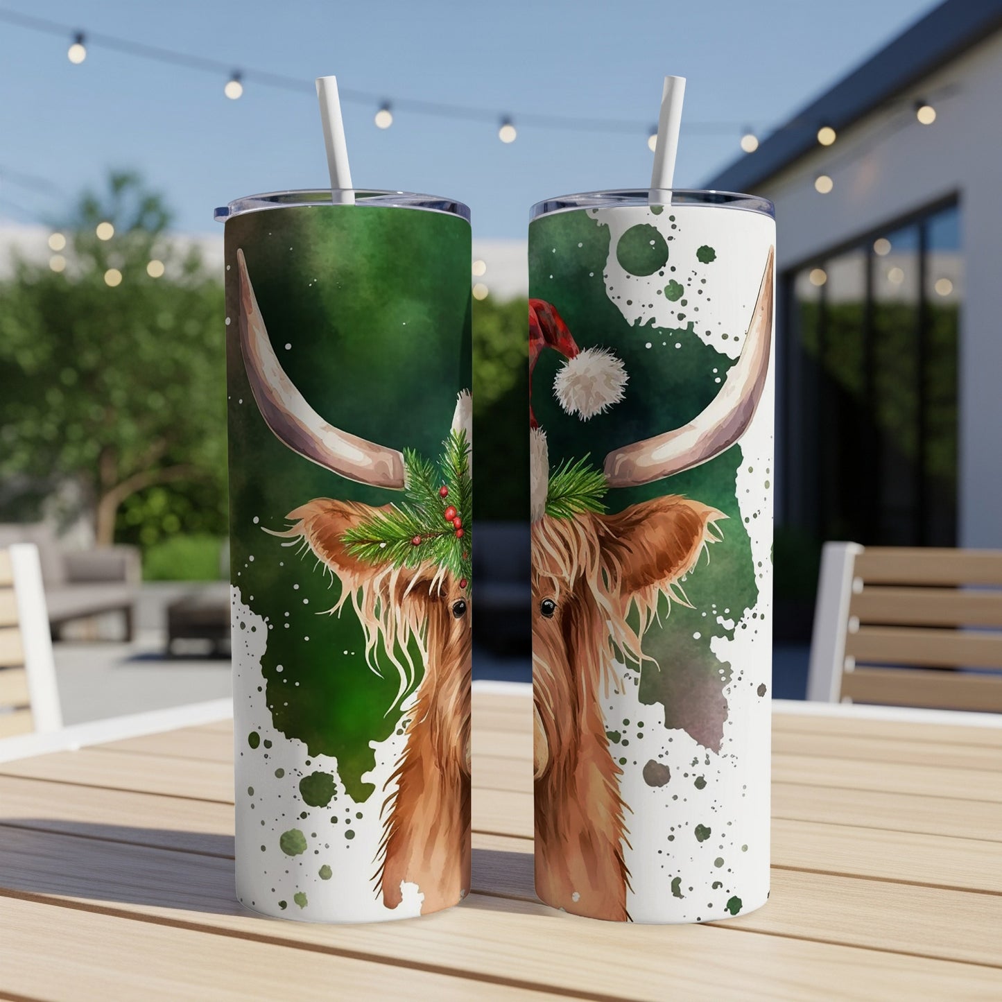 Two festive Highland cows with Christmas hats and greenery on tumblers.