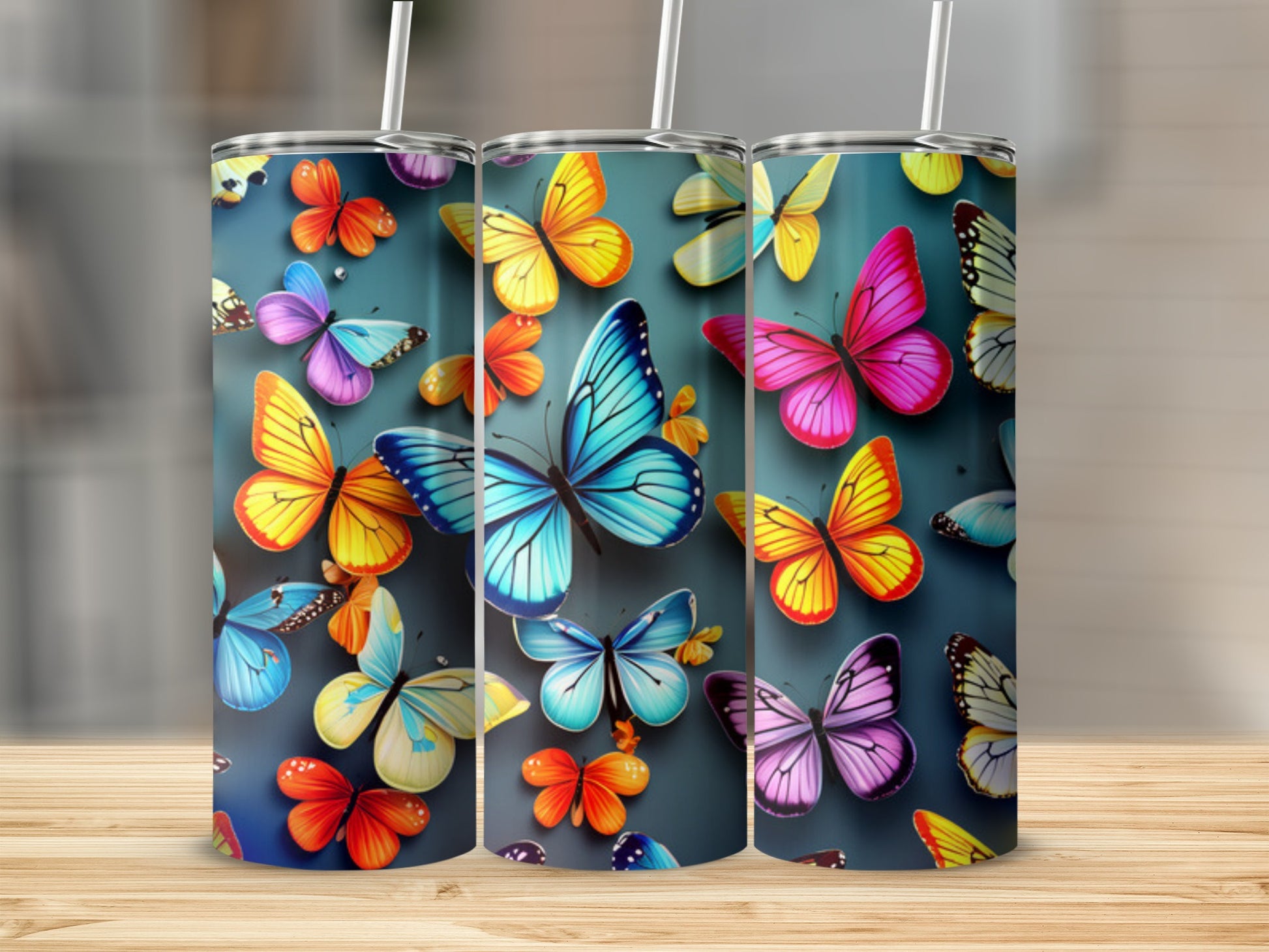 Three tumblers featuring colorful butterflies on a teal background.