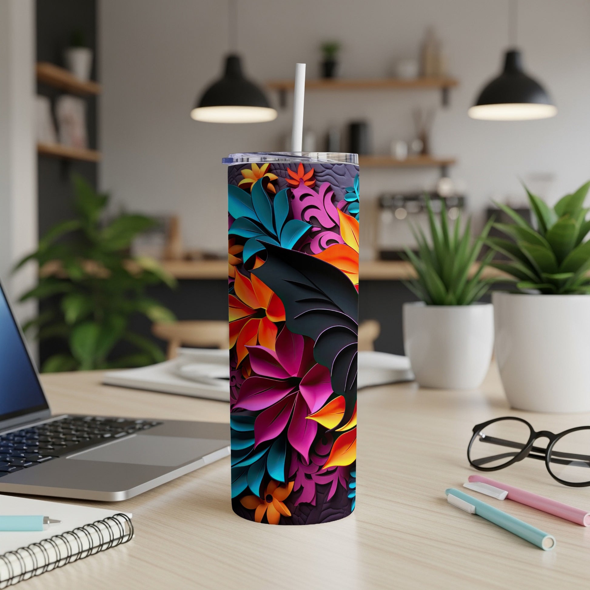 Tumbler with colorful floral pattern, white straw, on a desk.
