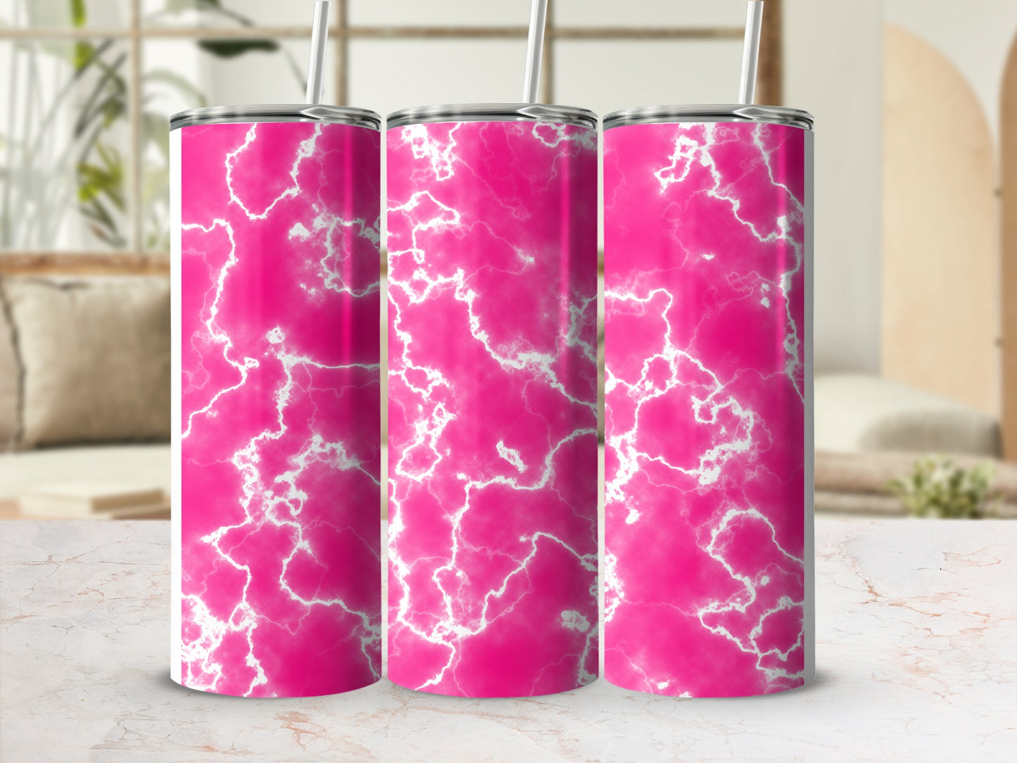 Three pink marble pattern tumblers with straws on a marble countertop.
